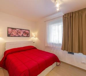 里米尼Miramare casa vacanze的白色的窗户客房内的一张红色的床