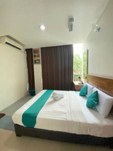 Kampong KerayongSun Tree Hotel的一间卧室配有一张带绿色和白色枕头的大床