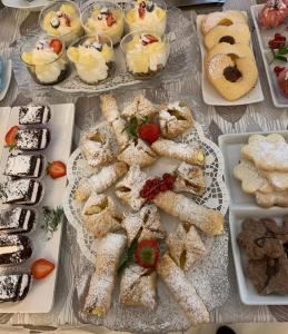 里米尼帕乌拉别墅酒店的盘子上带不同种类甜点的桌子