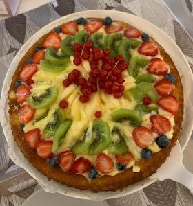 里米尼帕乌拉别墅酒店的桌上的盘子上带水果的比萨饼