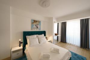 北马马亚-讷沃达里Castelana Infinity Beach Pool&Spa Mamaia Nord的一间卧室配有一张白色床和绿色床头板
