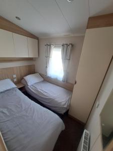 布莱克浦45 Sandringham的小房间设有两张床和窗户