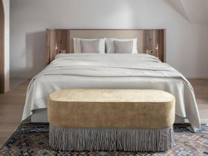 梅拉诺Villa Helvetia的一间卧室配有一张大床和一个大搁脚凳