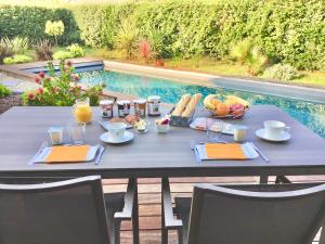 居让梅斯特拉La villa du golf的一张桌子,上面放着食物和饮料,还有一碗水果