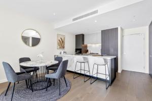 悉尼Macquarie Park Executive 2 Bedroom的厨房以及带桌椅的用餐室。