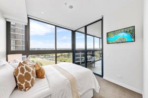 悉尼Macquarie Park Executive 2 Bedroom的卧室设有白色的床和大窗户