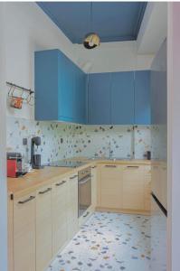 约阿尼纳HOME OF THE SOUL的厨房配有蓝色橱柜,铺有瓷砖地板。