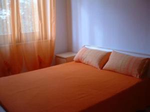 圣维托罗卡波Villa 2M a 50 metri dal mare的一间卧室配有一张橙色床和窗户