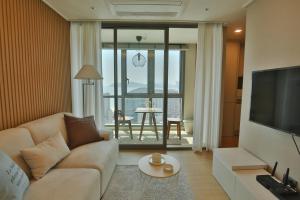 釜山premium ocean view in HAEHUNDAE BONA TRAVEL的带沙发和电视的客厅