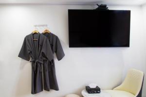 堤川市Number 25 Hotel Jecheon的挂在椅子旁边的墙上的黑色长袍