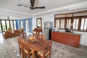 博瓦隆La Belle Residence Self Catering Accommodation的厨房以及带木桌和椅子的用餐室。