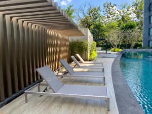 普吉镇Aristo Resort Surin Beach J16的游泳池旁的一排躺椅