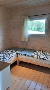 皮什Domki Wysokie Trawy Zdory的小木屋内的两张床,设有窗户