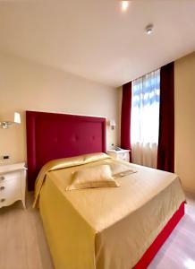 特尔尼迪亚曼特罗索酒店的一间卧室配有一张大床和红色床头板