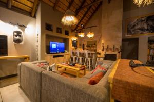 侯斯普瑞特Lindiwe Safari Lodge的带沙发和电视的客厅