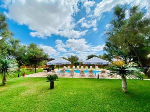 坎波斯Finca Sa Canova Agroturismo的一个带游泳池、椅子和树木的度假酒店
