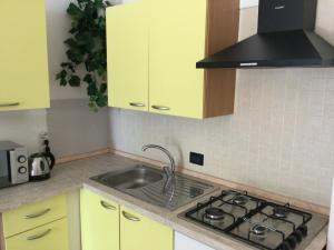 圣凯撒利亚温泉Residence Porto Miggiano的厨房配有黄色橱柜和水槽