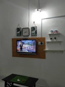 JeliRumah Tamu FieSari Jeli M U S L I M的墙上的电视,房间带桌子
