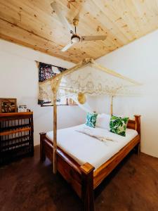 吉汶瓦The Kichwa House的一间卧室设有一张带木制天花板的天蓬床。