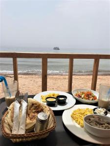 努韦巴Sinai Life Beach Camp的海滩上一张带食物盘的桌子