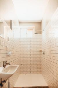 吉汶瓦The Kichwa House的白色瓷砖浴室设有水槽和窗户