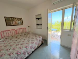 伊斯基亚Appartamenti Miramare in Collina的一间卧室设有一张床和一个滑动玻璃门