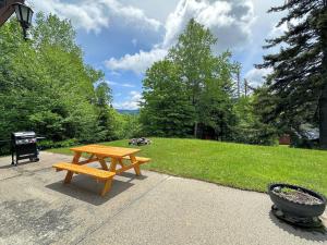 布雷顿森林26CM - private camp in Bretton Woods, wifi, AC, private yard with great views!的木餐桌,坐在公园的人行道上