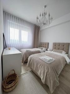 乌罗舍瓦茨Modern, City/Industrial Style的一间白色卧室,配有两张床和吊灯