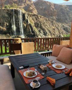索瓦马迈因温泉酒店的一张桌子,上面有食物,后面有瀑布