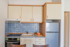 卡利塞亚-豪客迪克斯Erifili House的厨房配有白色橱柜、水槽和冰箱。