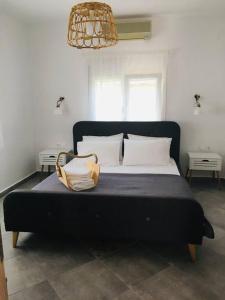 奥林匹亚达Babushka Apartments的一张带白色枕头的黑色床和钱包