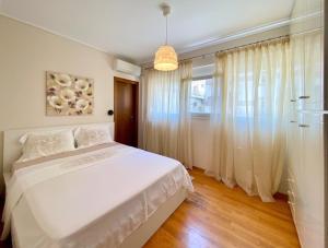 塞萨洛尼基East Coast Thessaloniki的卧室配有白色的床和窗户。