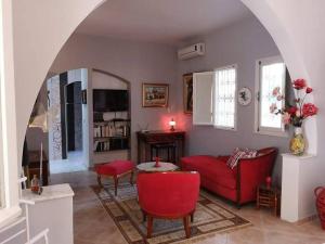 阿格希尔Chambre d'hôtes, Dar l'air du temps的客厅配有红色的沙发和桌子