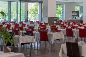 里姆斯克·托普利采Rimske Terme Resort - Hotel Sofijin dvor的一间设有桌椅和红色椅子的房间