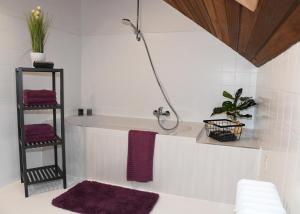 蒙绍Ferienhaus Dröfter Blick的带浴缸和紫色毛巾的浴室