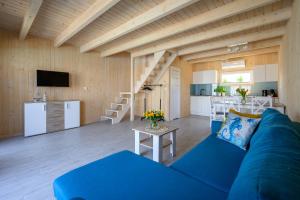 雅罗斯瓦维茨Resort Za Lasem的一间带蓝色沙发的客厅和一间厨房