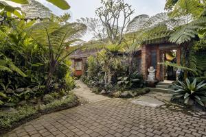乌布Roshan Ubud Villa的花园里有砖砌的走道的房子