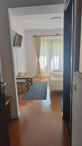 阿列谢尼Pensiunea Trei Brazi Arieseni的一间卧室配有一张床、一张桌子和一个窗户。