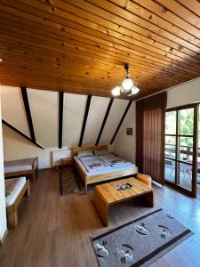 比哈奇Prenoćište/Restoran Lovac的客房设有两张床和木制天花板。