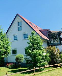 梅肯博伊伦SEEMOMENTE nahe Messe, Spieleland, Friedrichshafen的白色房子,有红色屋顶