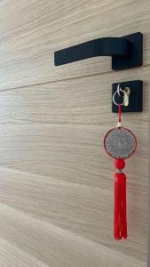 土伦VILLA HOLISTIKA : BED AND BREAKFAST / POOL / AIR CONDITIONING/ MONT FARON TOULON的挂在门上的红色 ⁇ 子,有钥匙