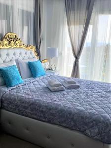 斯卡拉马里昂Chrystal Boutique Suite的卧室内的一张带蓝色枕头的大床