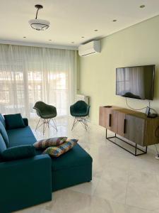卡瓦拉Down town villa Kavala的客厅配有蓝色的沙发和平面电视。