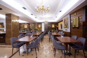 伊斯坦布尔大蚂蚁酒店的餐厅设有木桌、椅子和吊灯。
