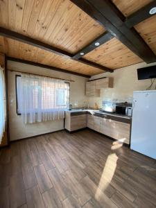 ZhvanetsВоллен的大型厨房设有木制天花板和白色冰箱。