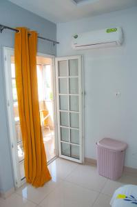 洛美Résidences 509的一间设有黄色窗帘和滑动玻璃门的房间