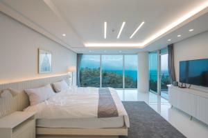 釜山500m2 Busan Ocean view private Let house 부산 오션뷰 3개층 대저택 독채펜션 렛하우스的一间卧室设有一张大床和一个大窗户