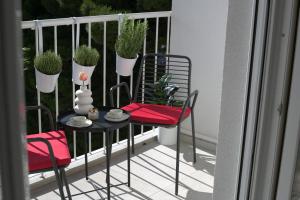 斯普利特Mint Apartment的阳台配有桌椅,种植了盆栽植物