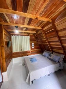 迈里波朗Belas Águas Mairiporã的木天花板的客房内的一张床位