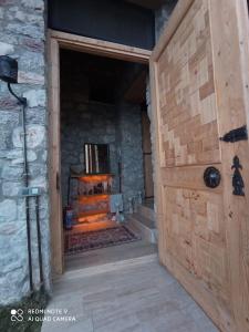 费特希耶19th Century Neo-Modern KABAK VALLEY STONE HOUSE的木门通往带壁炉的房间
